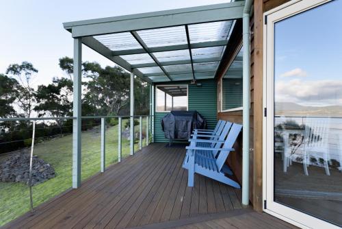 a screened porch with a bench on the deck at Scenic Getaway with Breathtaking Water Views in Gordon
