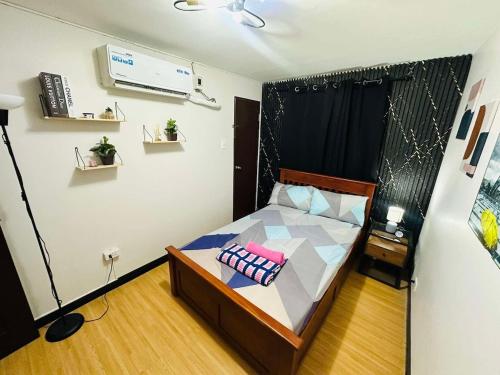 ein kleines Schlafzimmer mit einem Bett und einem Fernseher in der Unterkunft Reyes Haven - Urban Deca Marilao in Marilao