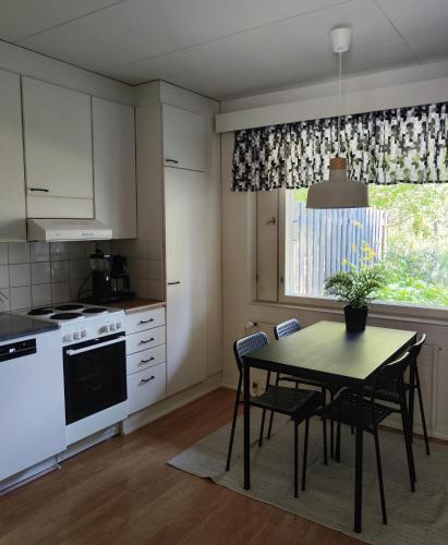 a kitchen with a table and chairs and a window at Honkatilat majoitus as 2 in Kajaani