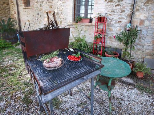 a grill with a table and a plate of food on it at Farmhouse in Gualdo near Lake Trasimeno in Gualdo Cattaneo