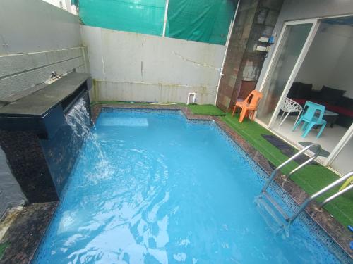 a small swimming pool with a table and a chair at Sky line villa, Lonavla in Lonavala