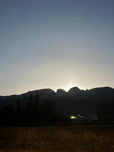 a view of the sun setting over the mountains at Chambre d'hôtes AU CHAUVET in Bésayes