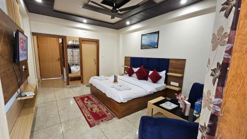 a bedroom with a large bed with red pillows at Hotel Green View McLeod Ganj in Dharmsala