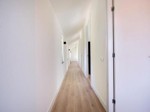 an empty hallway with white walls and wooden floors at Family House in Grou near Water Sports in Grou