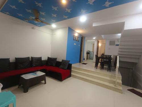 a living room with a couch and a dining room at Sky line villa, Lonavla in Lonavala