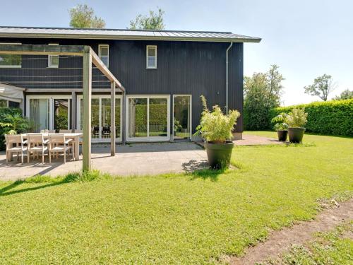 a black house with a patio and a table at Family House in Grou near Water Sports in Grou