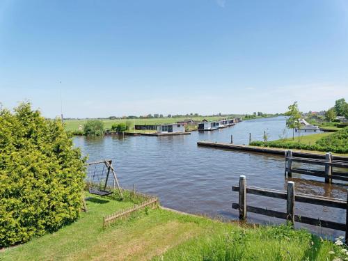 a river with a dock and boats in the water at Family House in Grou near Water Sports in Grou
