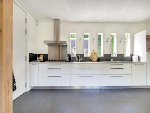 a kitchen with white cabinets and a stove at Family House in Grou near Water Sports in Grou