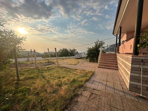 a house with a brick walkway next to a building at Xhiu guest house in Krujë