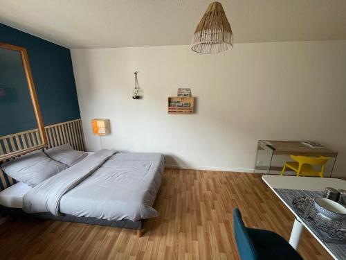 a bedroom with a bed and a table with a table at Trank'il appart in Marmande