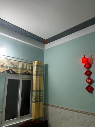 a room with a window and a red flower on the wall at Lý Sơn I Xuân Mai Homestay in Quang Ngai
