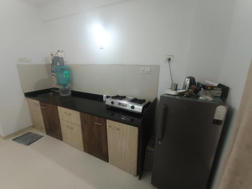 a kitchen with a black refrigerator and a stove at Sky line villa, Lonavla in Lonavala