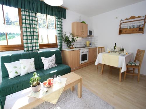 a living room with a green couch and a table at Apartment in Hüttschlag near Ski Bus in Hüttschlag