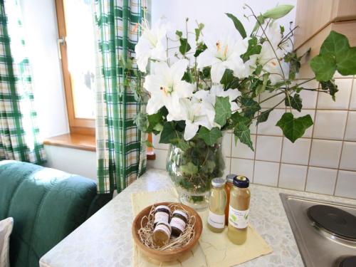 a vase filled with white flowers on a kitchen counter at Apartment in Hüttschlag near Ski Bus in Hüttschlag