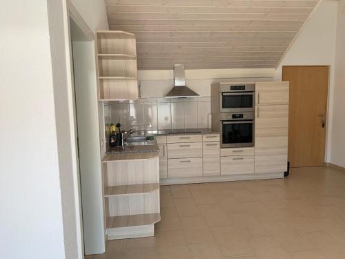a kitchen with white cabinets and stainless steel appliances at Homely 2,5 room apartment in Safenwil