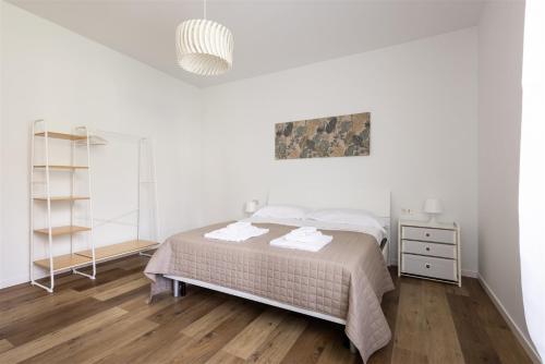 a white bedroom with a bed and a mirror at IseoLakeRental - Casa Le Betulle in Pisogne