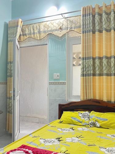 a bedroom with a yellow bed with a window at Lý Sơn I Xuân Mai Homestay in Quang Ngai