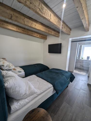 a bedroom with a bed and a flat screen tv at Król Puszczy - unikatowy dom, jezioro 80m, szlak Krutyni in Ruciane-Nida