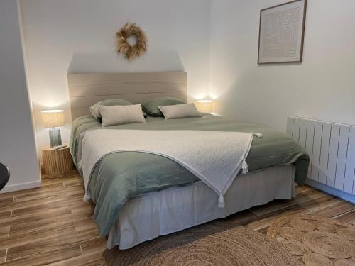 a bedroom with a large bed with two pillows at Charmant studio à 10 min de Lyon in Miribel