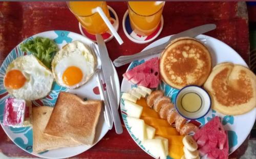 a table with a plate of breakfast food with eggs and toast at Goodluck village house in Koh Mook