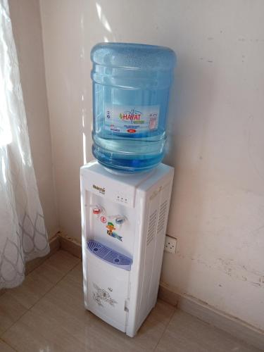 a bucket and a container on top of a refrigerator at Happiness Gardens in Lilongwe