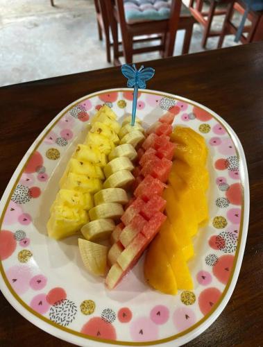 a plate of food with fruit on a table at Goodluck village house in Koh Mook