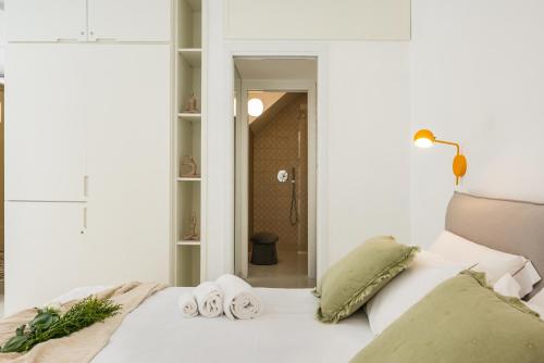 a bedroom with a white bed with towels on it at Anita Rooms in Olbia
