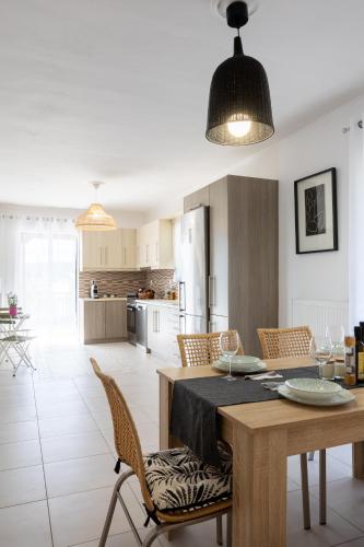 a kitchen and dining room with a table and chairs at SeaAuraApartment in Áyioi Apóstoloi