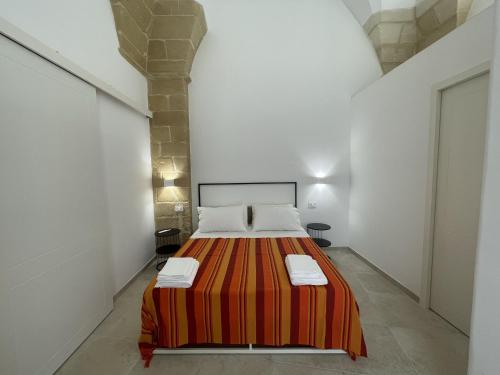 Un dormitorio con una cama grande en una habitación blanca. en Casa Sant'Ippolito, en Lecce