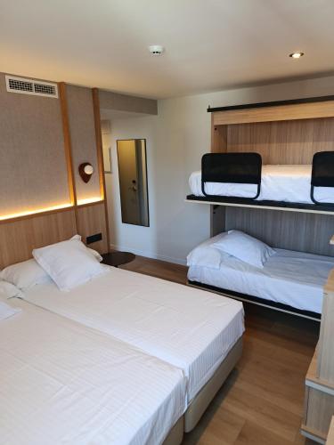 two beds in a room with two bunk beds at Hotel Las Rocas de Isla in Isla