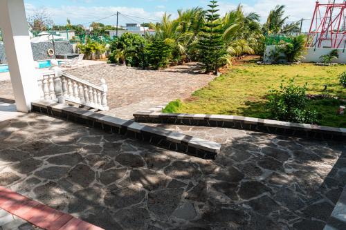 a stone walkway with a bench in a yard at Allee coco in Trou aux Biches