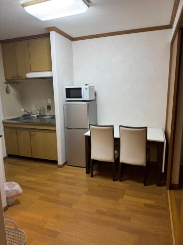 a small kitchen with a table and two chairs at izu花縁 in Ito