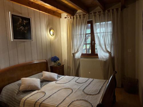 una cama en un dormitorio con ventana en Chalet Le DRUZIA at 1000 m, en Belfahy