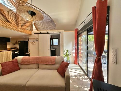 a living room with a couch and a ceiling at La Ptite Maison proche Rouen in La Vaupalière