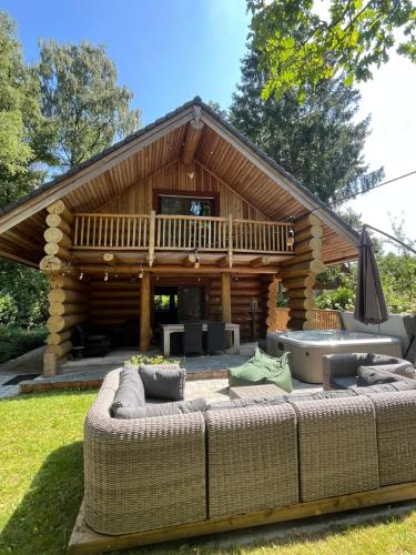 eine Blockhütte mit einer großen Couch im Hof in der Unterkunft the loghouse in Aalter