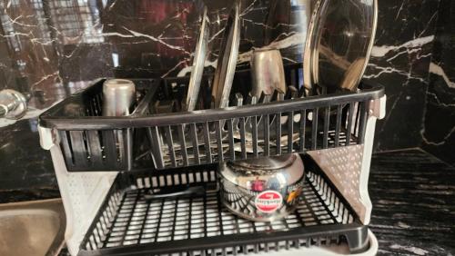 a metal shelf in a dishwasher with a cup at Shri Kishori Kunj in Barsāna