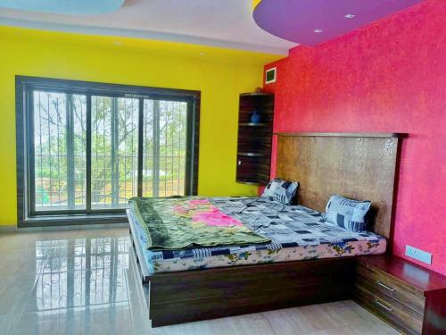 a bedroom with a bed with a colorful wall at The Secret Villa in Panchgani