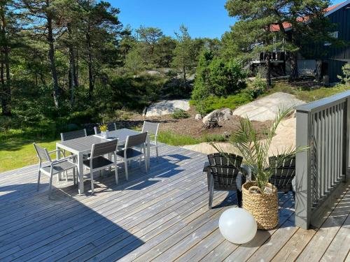 a patio with a table and chairs on a deck at Modern Cabin With A Short Walk To The Sea in Skjærhollen