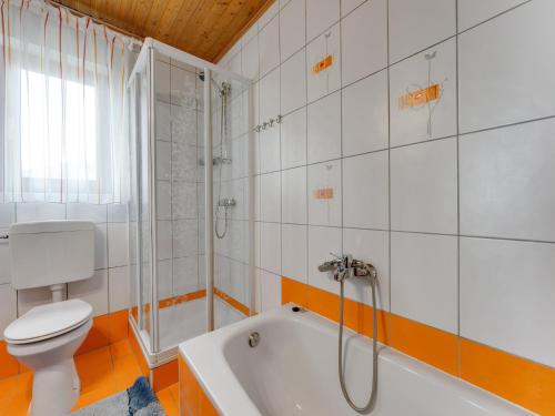a bathroom with a tub and a toilet and a shower at Chalet in Eberstein near Saualpe Ski Area in Eberstein