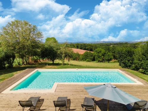 a swimming pool with chairs and an umbrella at Holiday home with pool in Coubjours in Coubjours