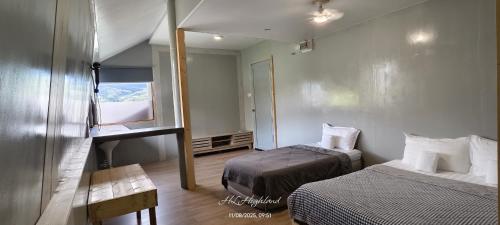 a small room with two beds and a window at Highland Homestay Kundasang in Ranau