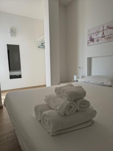 a white bedroom with towels on a bed at Casa indipendente Roque Vista al mar con parking gratuito in Vallecrosia