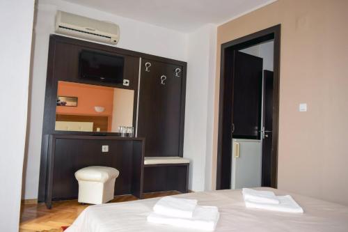 a bedroom with a bed and a cabinet with a television at Private Rooms Trakiets in Pomorie