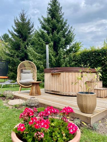 a patio with flowers and a chair and a wooden deck at Vila EVIO Třeboň in Třeboň