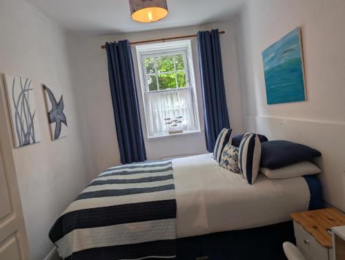 a bedroom with a bed and a window at Rose Court Holiday Apartments in Torquay