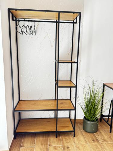 a metal and wood display rack with wooden shelves at Apartmán Mácháč in Doksy
