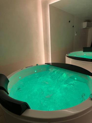 a hot tub in a bathroom with green water at Elite Suite in Castellana Grotte