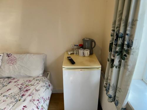 a small room with a small refrigerator and a bed at Seaside resort in Felixstowe