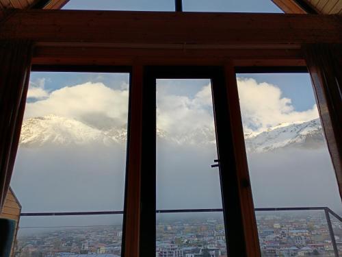 a view of a snow covered mountain through a window at Belas guesthouse in Stepantsminda