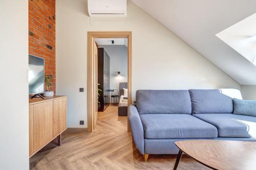 un salon avec un canapé bleu et une table dans l'établissement Domillion 1bdr New Old Town apt U2306, à Vilnius